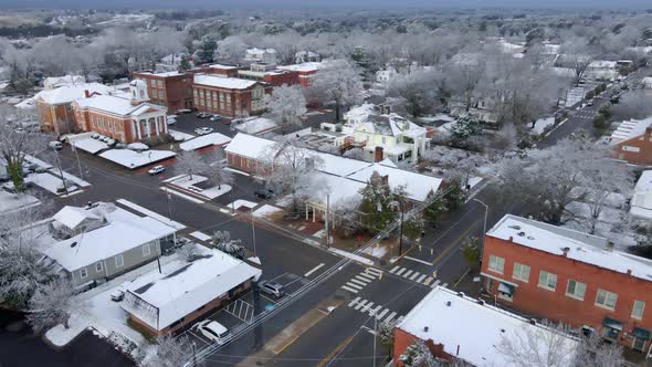 Drone shot of snow covered buildings in a small town USA