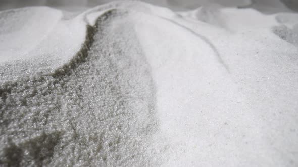 Camera Pans Over a Mound of Dry White Sand