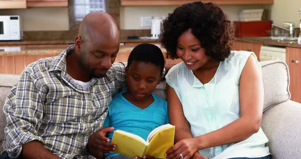 Family reading a book in living room 4k