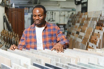 African american man choosing tiles at building market