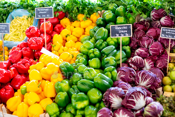 colorful vegetables displayed at a market in italy with price tags