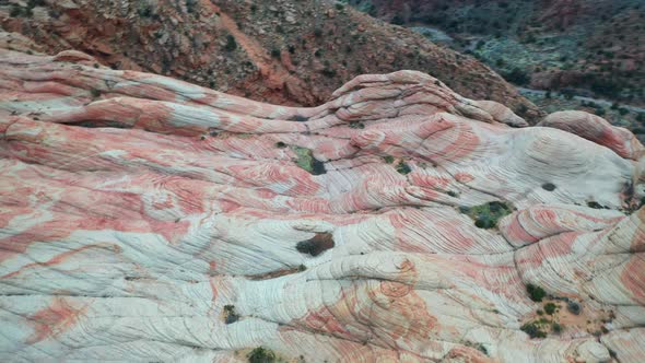 View from a drone of a massive rock formation with a red-orange marble texture in the mountains duri