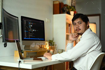 Young professionals web developer writing code on computer monitor at workstation