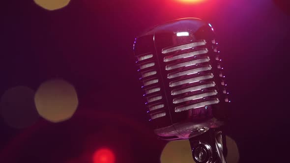 Vintage Shiny Microphone Reflects Glitter Confetti Against Blurry Flashing Lighting