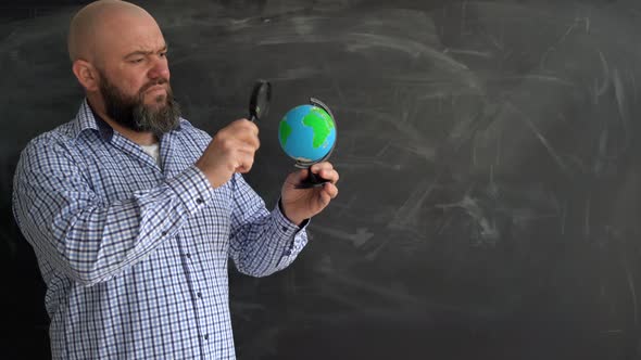 Adult Bearded Bald Caucasian Man Stands Near the School Chalk Board