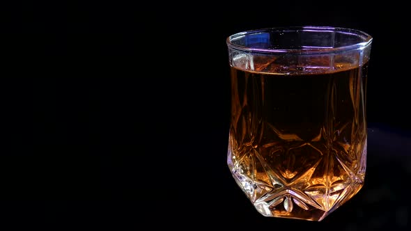 on a dark background in a glass beaker golden liquid.