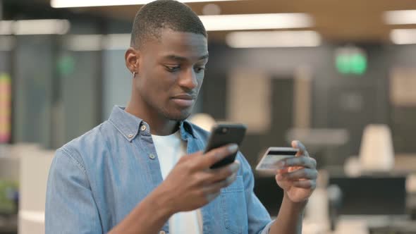 Young African American Man Making Online Payment on Smartphone