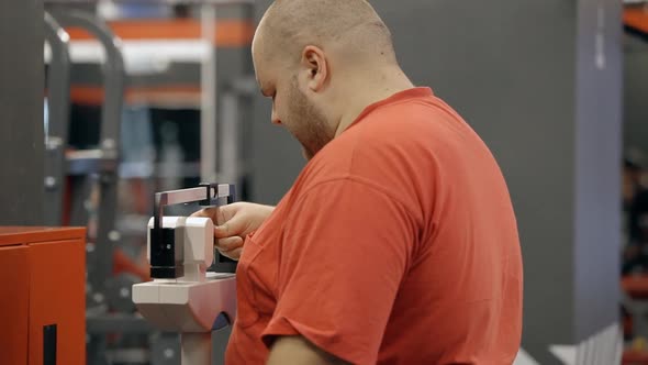 Young Overweight Man Standing in Gym on Mechanical Scale