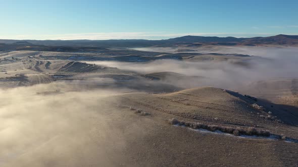 Flying Over Misty Hills in Foggy Winter Morning