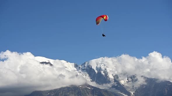 Paraglider Above Snowy Mountain Peaks Enjoying His Flight