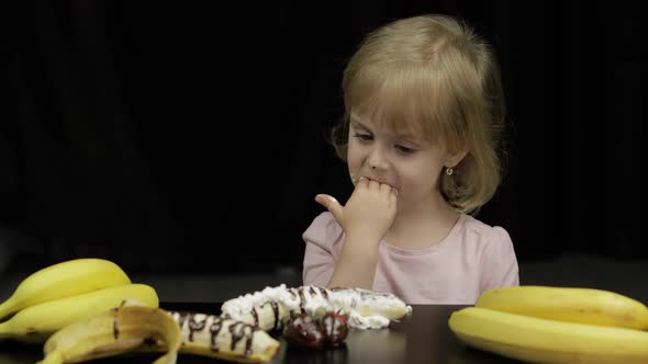 Child Eats Banana, Strawberry with Melted Chocolate and Whipped Cream