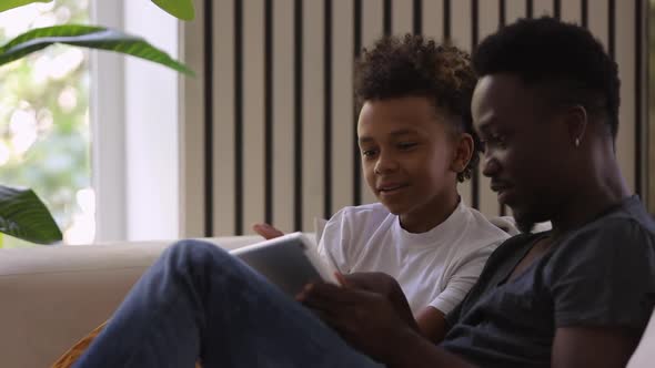 African American Man Boy Talking and Using Tablet on Sofa at Home Room Spbi