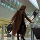 The Girl at the Airport is Late for the Plane and in a Hurry Leaves the Escalator and the Suitcase - VideoHive Item for Sale