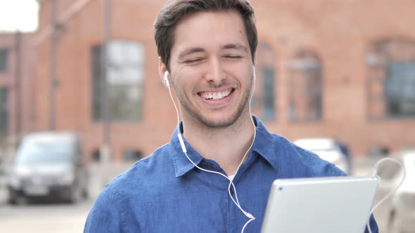 Young Man Listening Music on Tablet