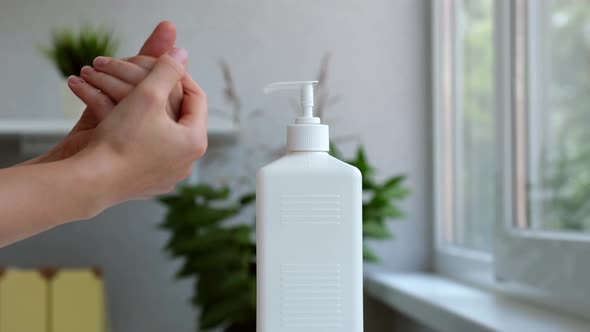 Woman Disinfecting Hands with Sanitizer Dispenser