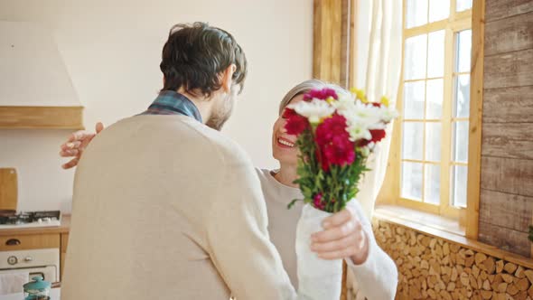 Young Man Congratulating His Elderly Mother with Bouquet of Flowers Grateful Greyhaired Woman