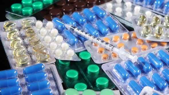 Some Different Contraceptive Pills and Syringe, Rotation, Reflection, Top View