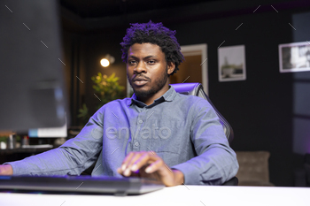 Man in living room playing engaging video games on gaming PC at computer desk