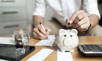 Savings and finance concept. man putting money coin in piggy bank for saving money.