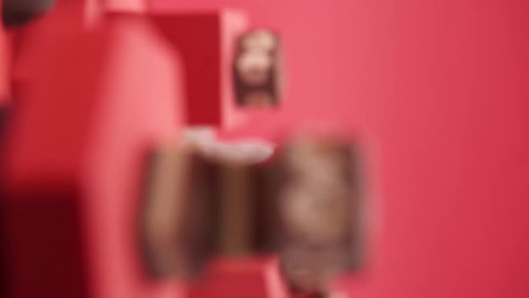 Vertical video, Close up: Composition of chocolate and candies on a red background