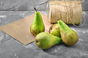 Green pears on a gray background with a paper bag for delivery, food delivery, environmental