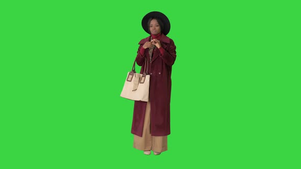 Fashionable Black Woman Standing and Waiting on a Green Screen, Chroma Key.