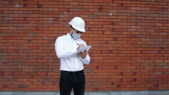 Wide Frame with a Caucasian Engineer Wearing Special Equipment and a Protective Mask