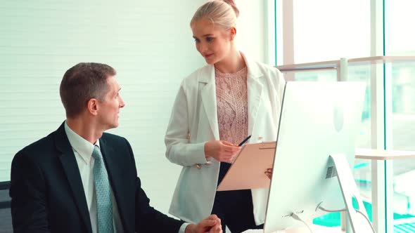 Two Business People Talk Project Strategy at Office