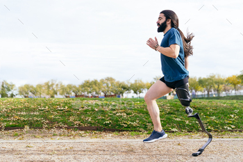 Bearded Athlete Using Prosthetic Leg Sprints on Park Pathway
