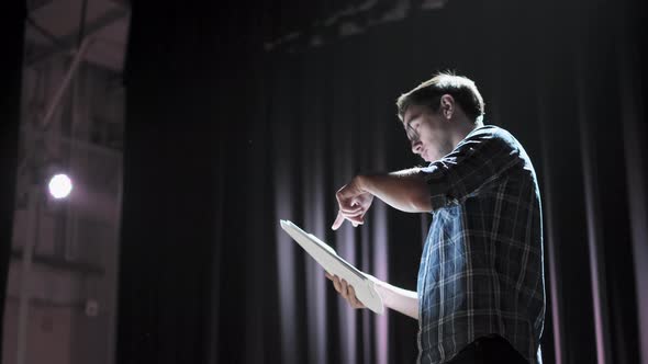 Stand Up Comedian on Stage. Young Man Talks Joke Into Microphone or Sings Songs