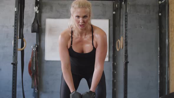 Strong Woman Doing Dumbbell Side Raises in Gym alt