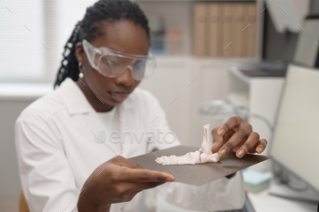 Female Scientist Inspecting 3D Printed Sample in Lab