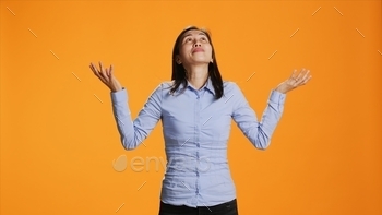 Spiritual woman praying to Jesus in front of orange background