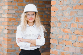 beatiful woman engineer is reviewing the plans of a construction work