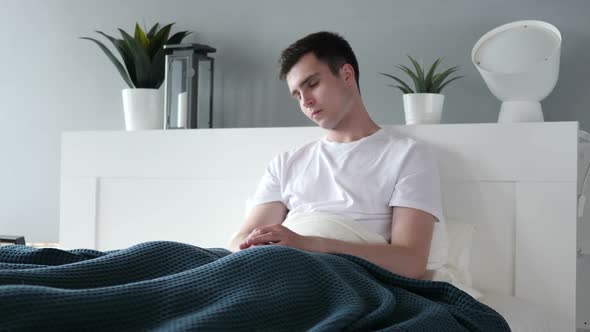 Man Sitting and Sleeping in Bed