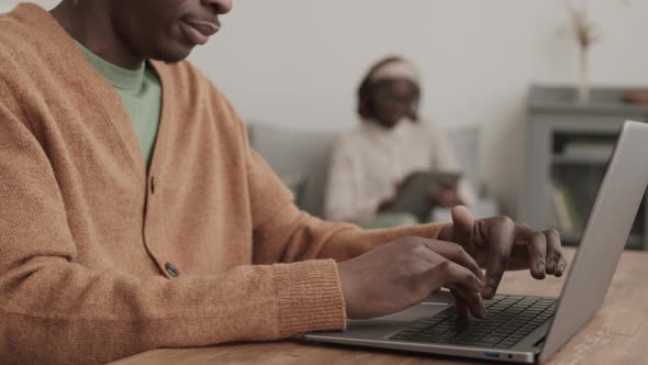 African Man Typing on Laptop Keyboard