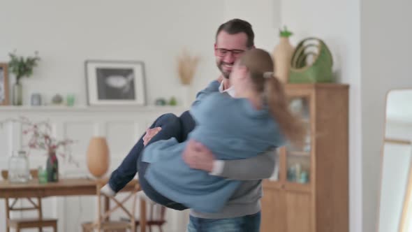 Middle Aged Man Holding Woman in Arms and Swirling