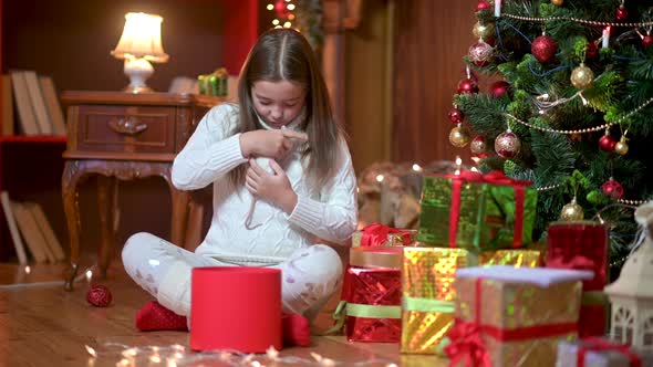 Cute girl sitting in the office on the floor near the Christmas tree