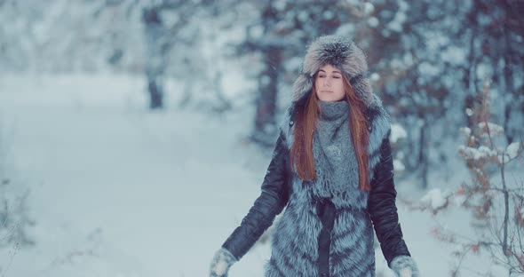 Beautiful Girl Walks Through the Winter Forest