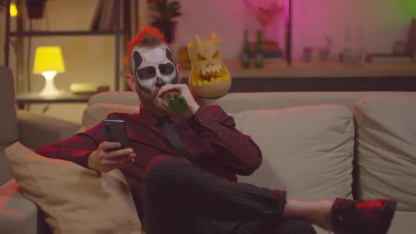  Man Enjoying Beer after Halloween Party at Home