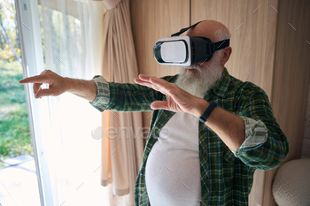 Elderly man plays in virtual reality glasses