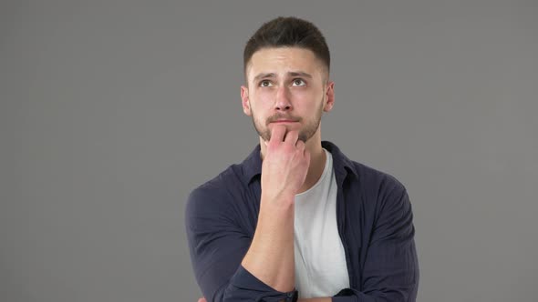 Portrait of Goodlooking Guy in Casual Clothing Posing with Doubting Look While Thinking or Weighing