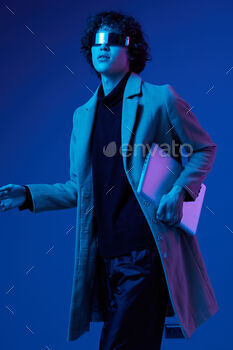 A man with a laptop in his hands and jacket, futuristic glasses in blue light, Blue Perennial color