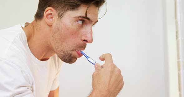 Young man brushing his teeth with toothbrush in the bathroom 4K 4k