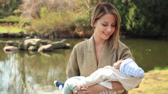 Young mother with a infant baby in spring time park