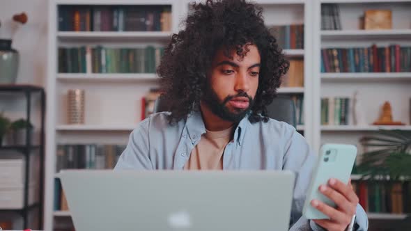 Young Arabian Man Entrepreneur Working with Laptop and Phone in Multitasking