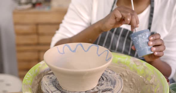 Young Black Woman Painting a Clay Bowl at Workshop