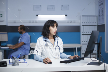 Doctor reviewing files on computer