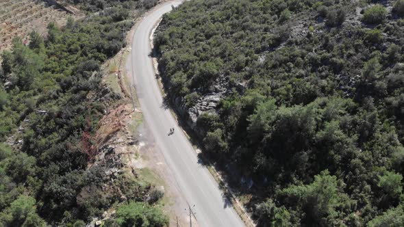 Cyclist is going downhill from mountains on bicycle