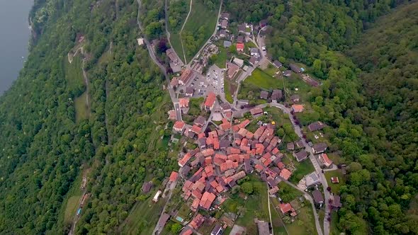 Aerial drone shot over the homes and buildings of Lugano on the edge of a lake in Switzerland.